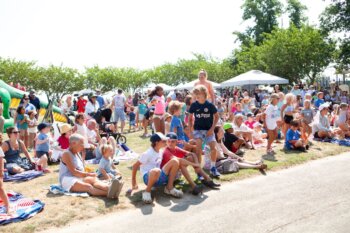 Crowd sitting on blankets.