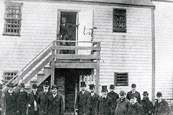 A crowd gathered in front of the jail, also known as the Old Gaol, 1893, when the Commission on Prisons inspected the jail.